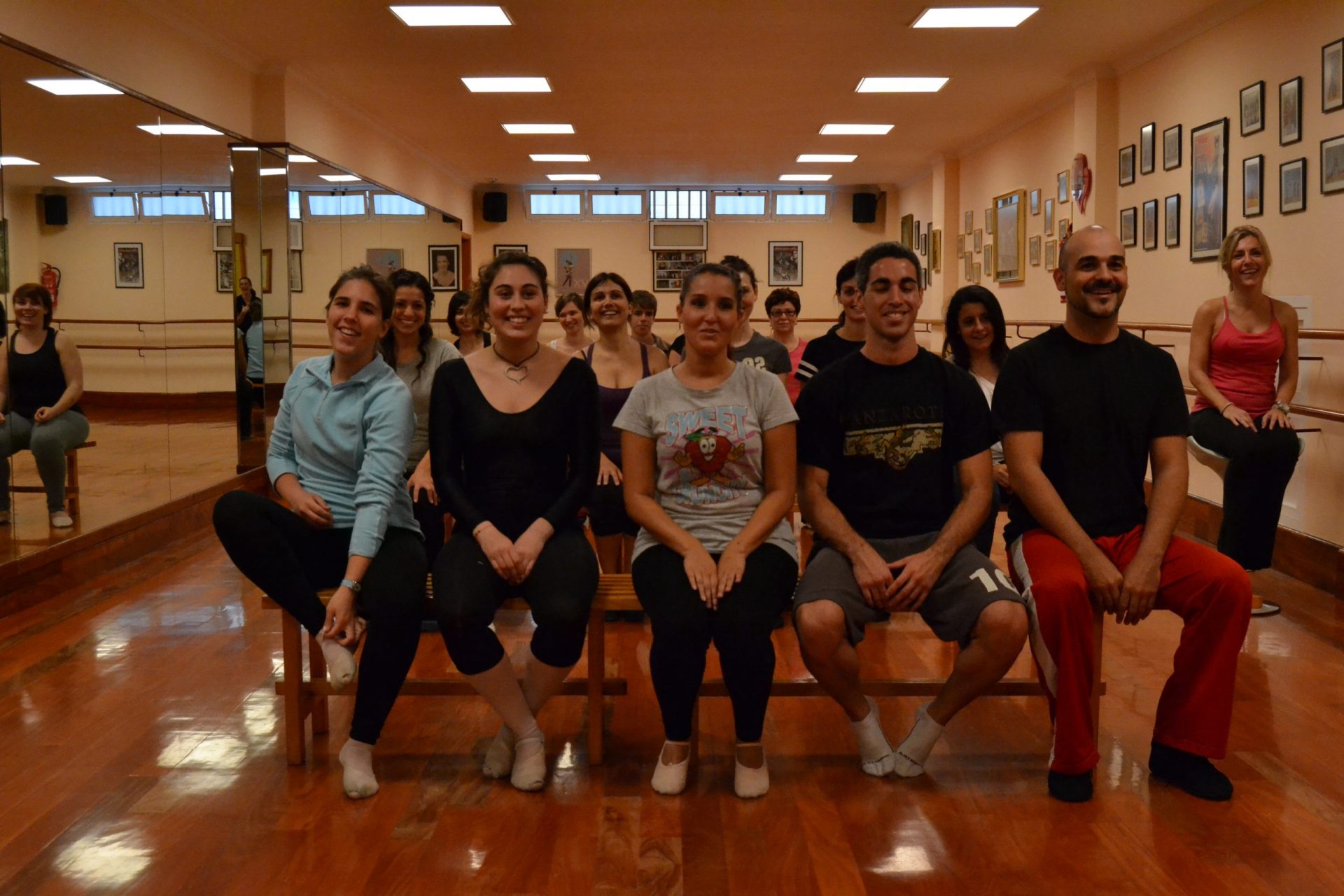 Foto en el Centro de Danza Sandra Santa Cruz de un grupo de bailarines sentados en bancos de madera en la sala de baile... No bailan se preguntarán, sí,  están ensayo del Flashmob en la Escuela Oficial de Idiomas de Las Palmas II.