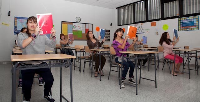 Foto del alumnado del Centro de Danza Sandra Santa Cruz sigue sentado pero empieza a animarse tras los libros en la Escuela Oficial de Idiomas. Así continúa su Flashmob...
