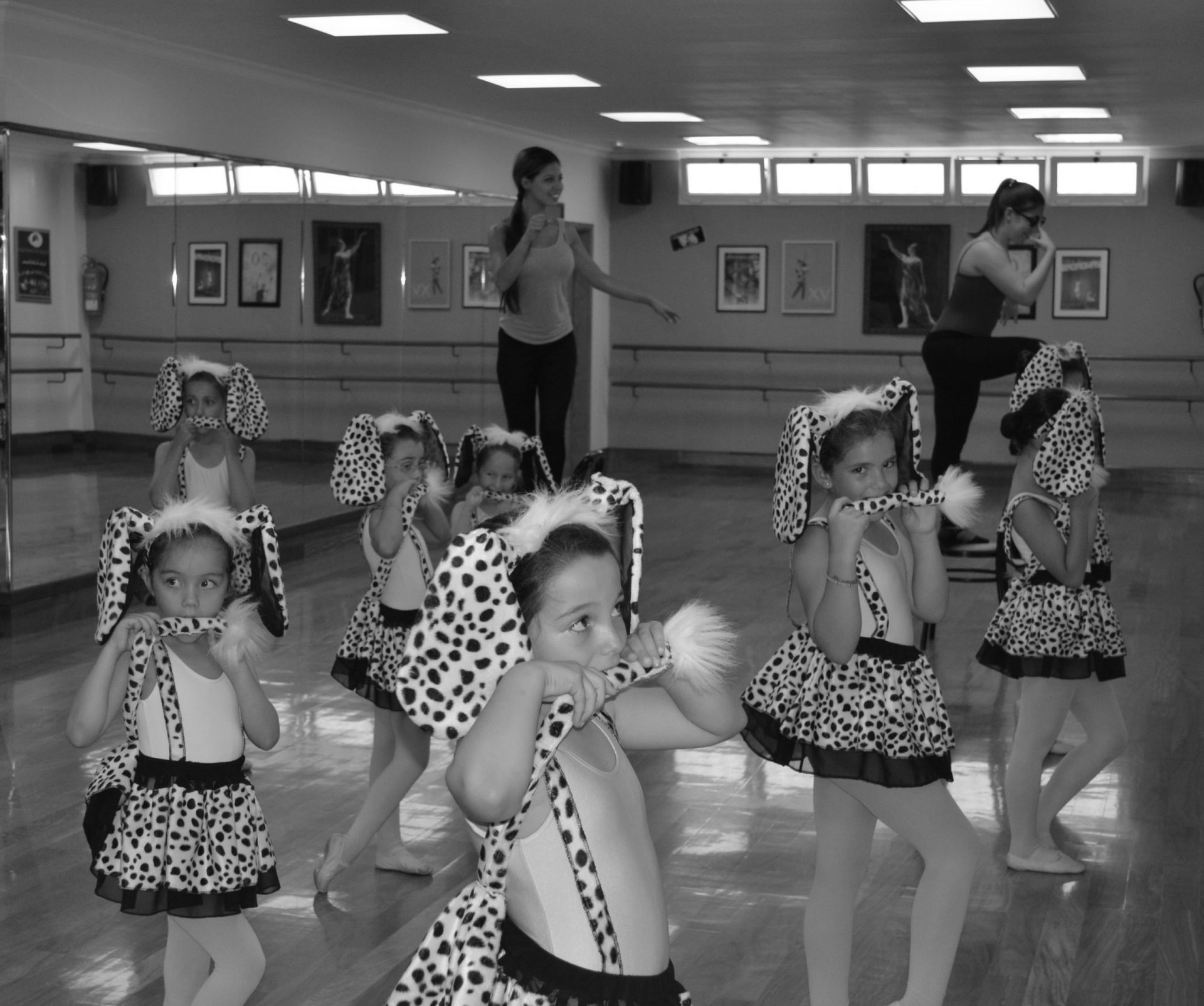 Foto de un grupo de alumnas de Predanza II de 6 años, vestidas de dámatas con una diadema con enormes orejitas y que, con una pose sexy se muerden el rabito que sale de sus faldas. Están en un ensayo del Centro de Danza Sandra Santa Cruz para los espectáculos para diciembre.