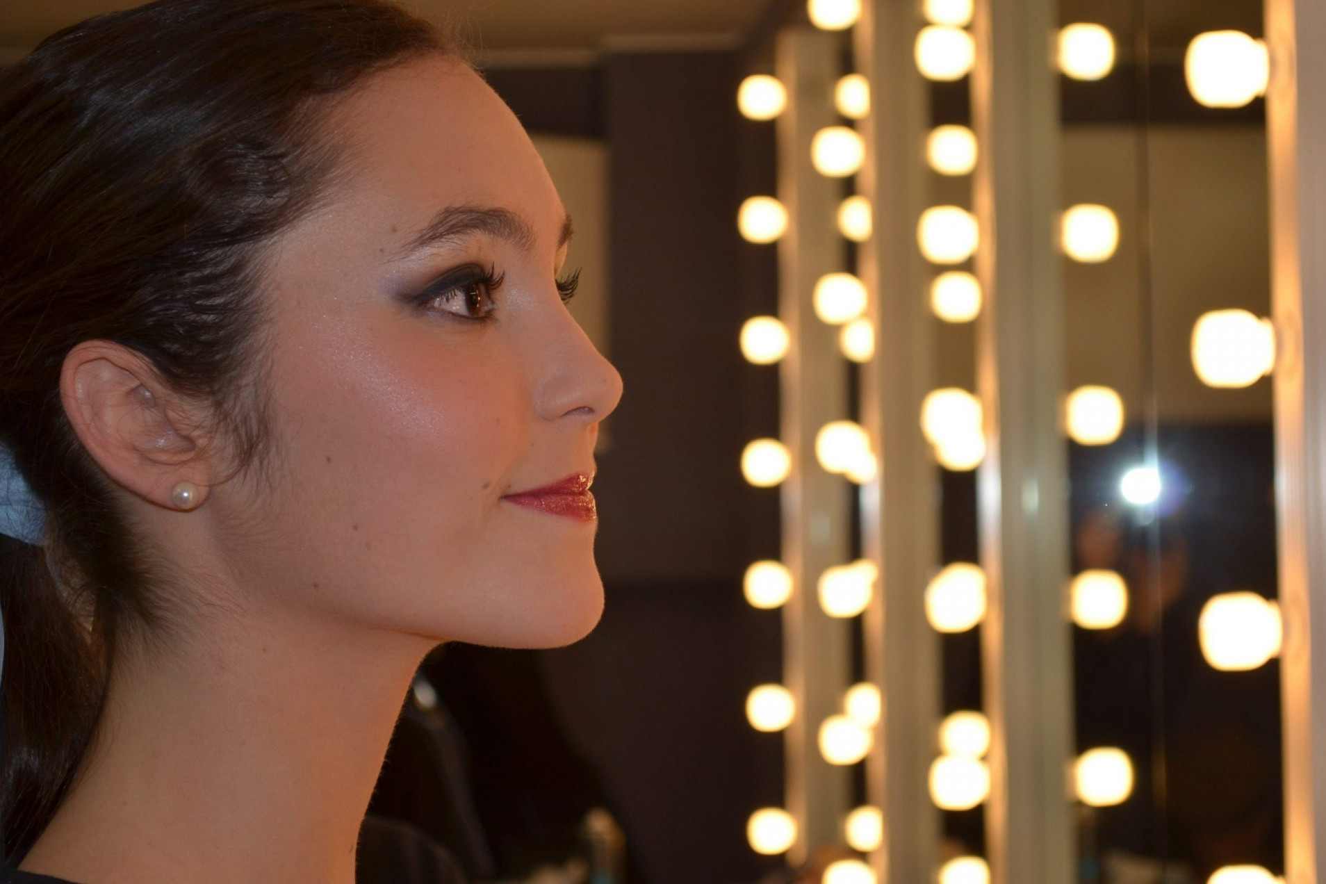 Foto de Carla Alonso,una bailarina del Centro de Danza Sandra Santa Cruz sonriéndo mientras se mira en el espejo de un camerino