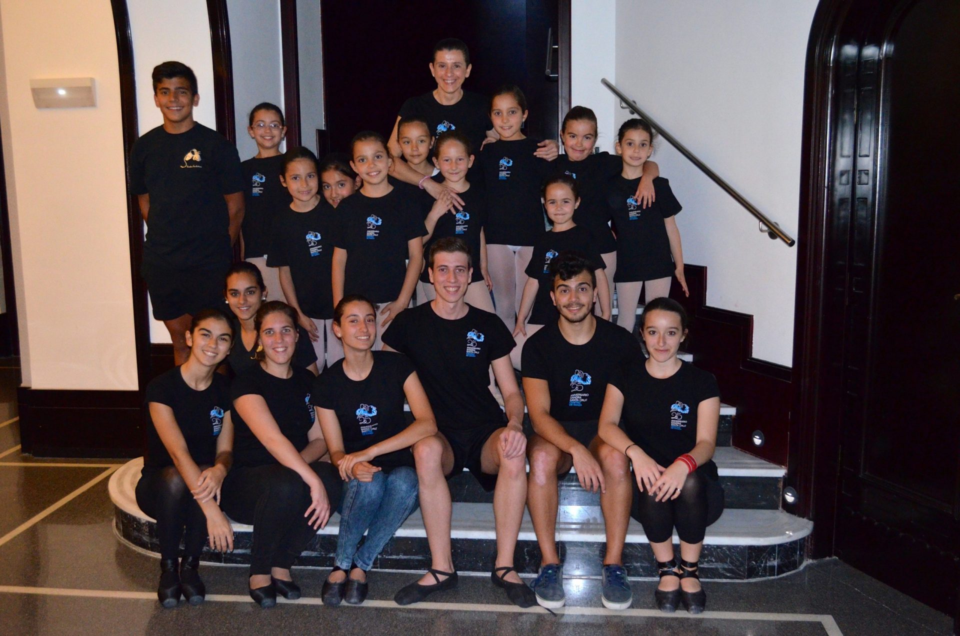 Foto de un grupo de baialrines del Centro de Danza Sandra Santa Cruz sentados en la escalera del Teatro Guiniguada para celebrar  el Día Mundial de la Danza