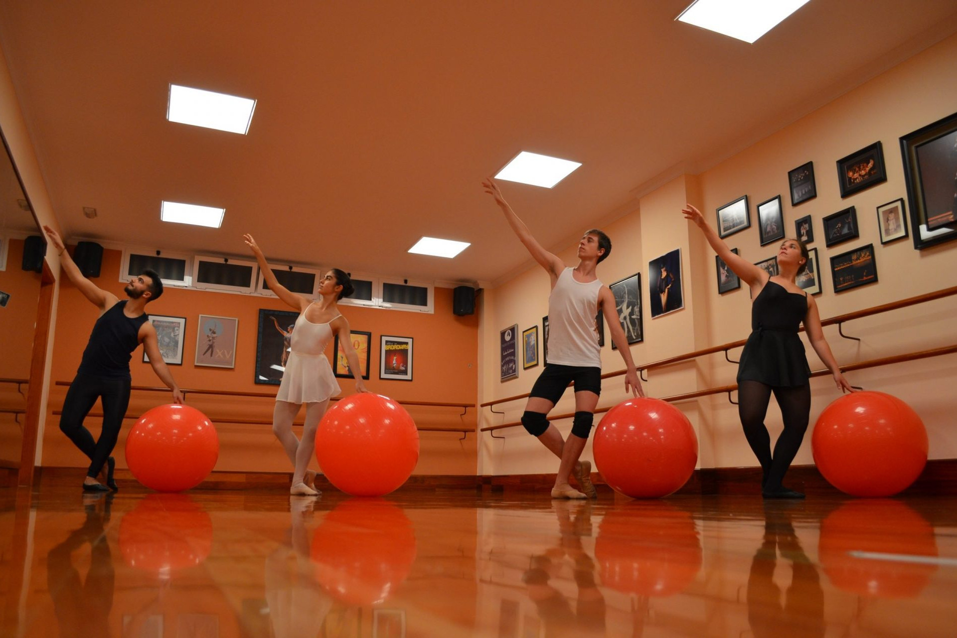Foto en el Centro de Danza Sandra Santa Cruz de un grupo de bailarines con una pelota grande durante una clase de Stretching con fit-ball y bandas elásticas para tener mejor forma física.