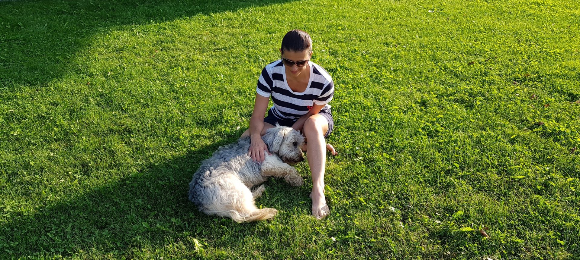 Sandra Santa Cruz sentada en un prado con Bobby, el perro de su hermana, lanza un SOS para salvar al planeta.