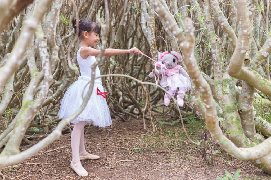Foto de una alumna de Predanza del Centro de Danza Sandra Santa Cruz en el bosque con una varita mágica que simboli