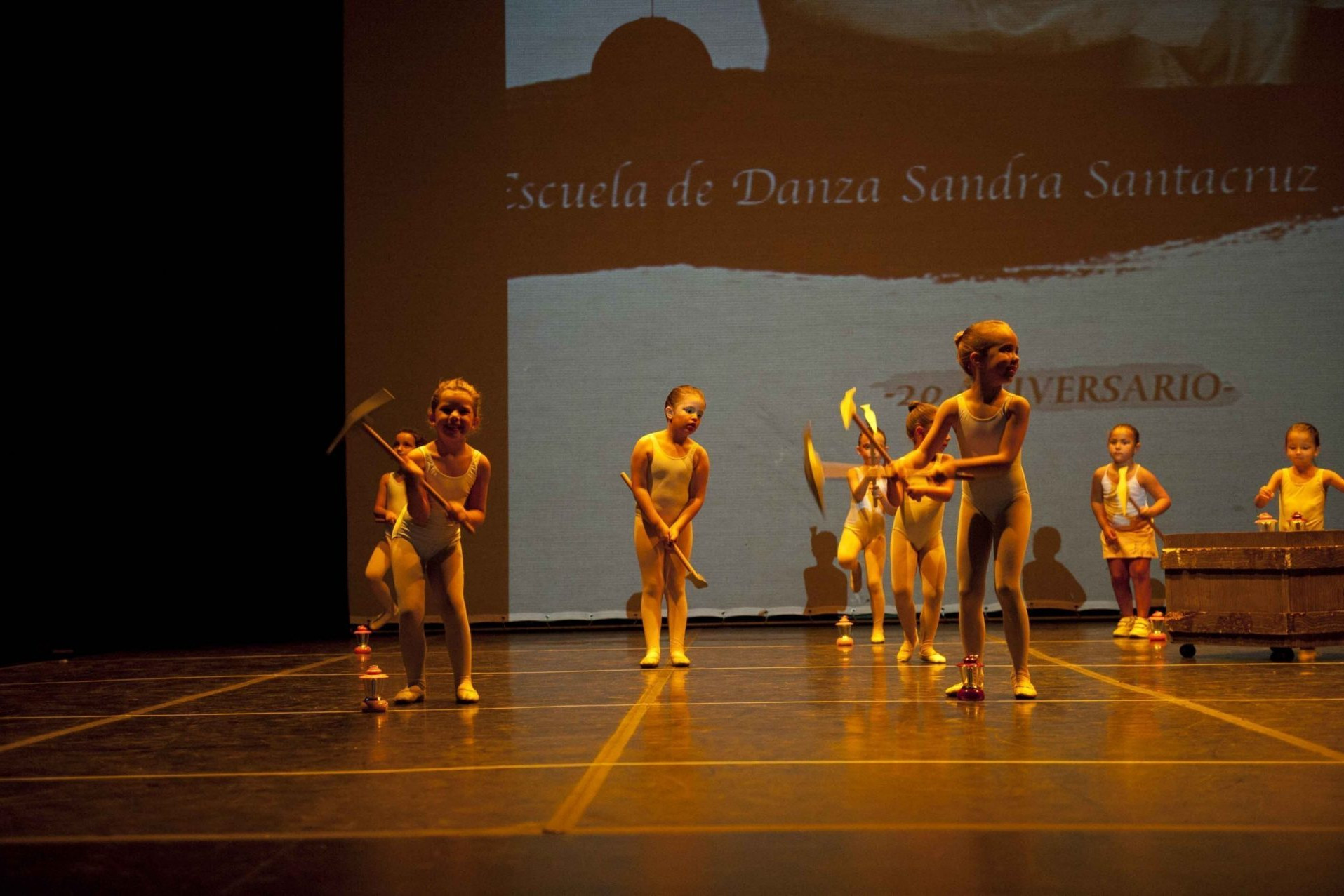 Foto del 20 Aniversario del Centro de Danza Sandra Santa Cruz donde las alumans de Predanza están en el escenario con unos picos y un carrito para bailar Blancanieves