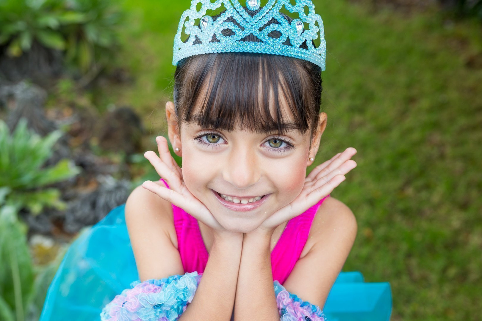 Foto de Ethel Barttrán de una alumna del Centro de Danza Sandra Santa Cruz con la cara apoyada sobre sus manos y una amplia sonrisa tras el 25 Aniversario del Centro..