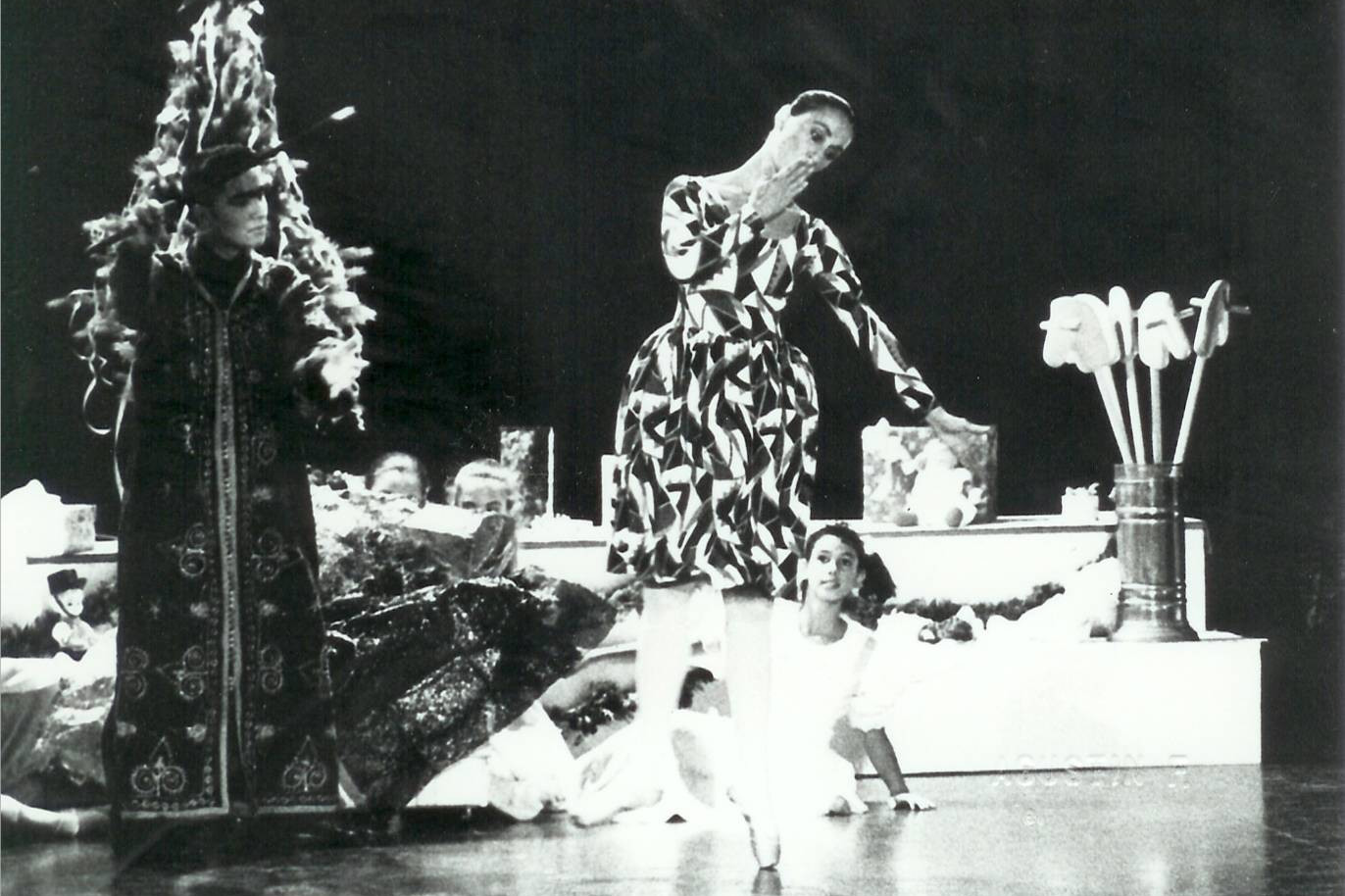 Foto de un fragmento de Cascanueces interpretado por la Compañía de Danza Sandra Santa Cruz donde baila la muñeca bajo la atenta mirada de los niños y Drosselmeyer.