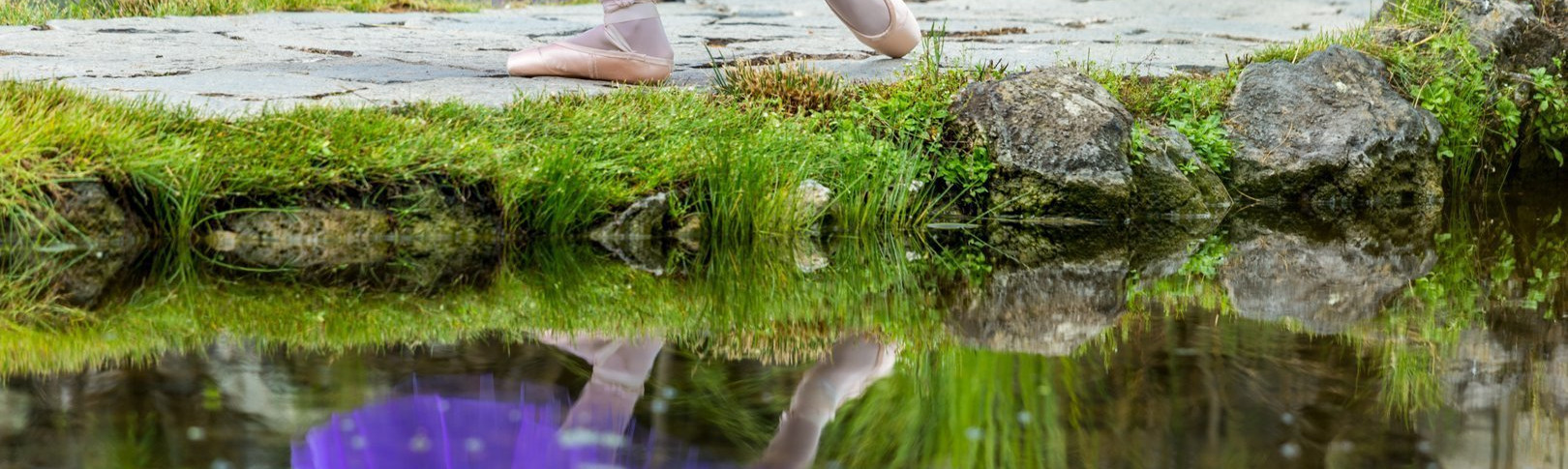 Foto de unos pies de una bailarina del Centro de danza Sandra Santa Cruzcon puntas que se reflejan en un lago. Nada mejor para explicar la importancia de la elección del modelo de puntas.