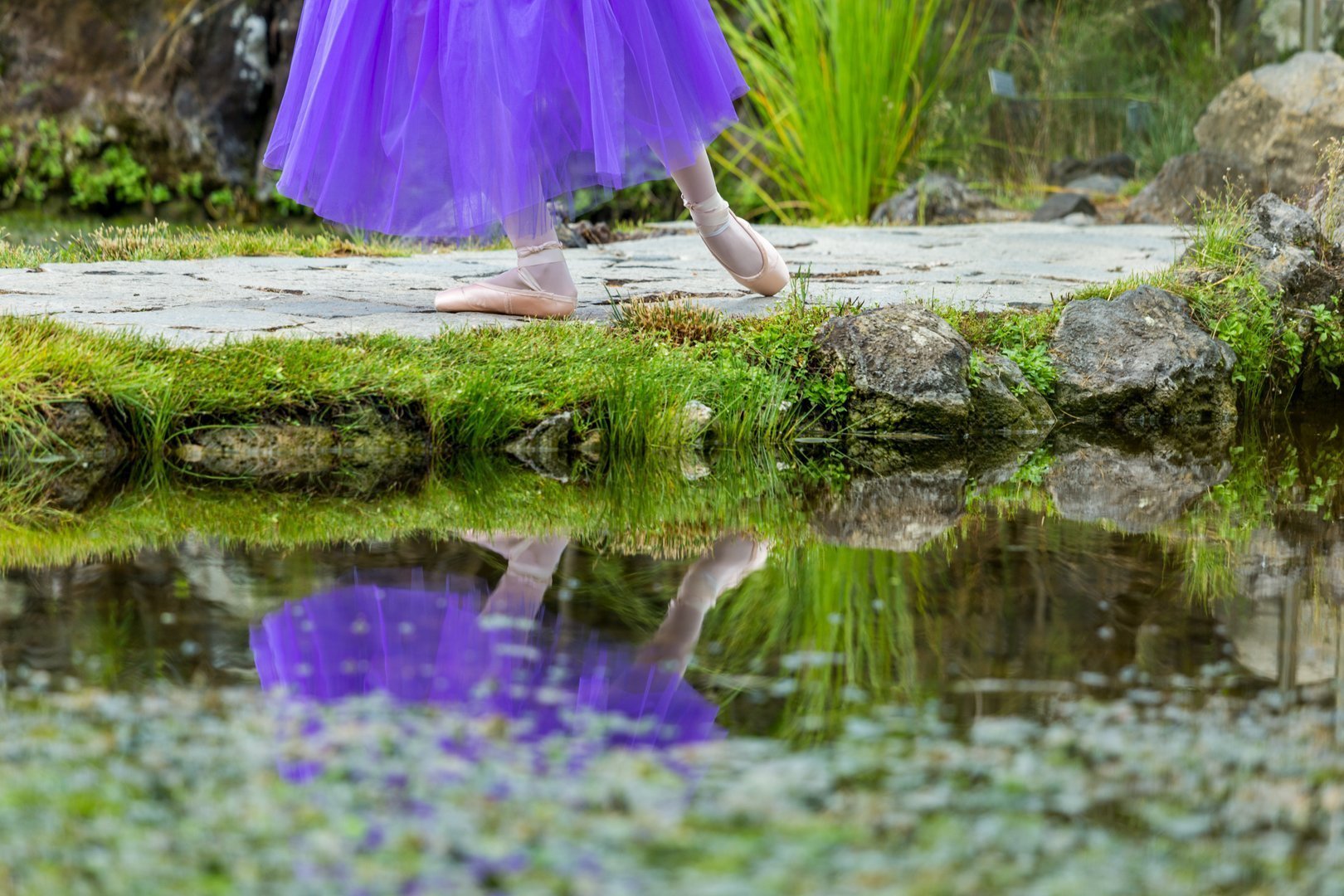 Foto de unos pies de una bailarina del Centro de danza Sandra Santa Cruzcon puntas que se reflejan en un lago. Nada mejor para explicar la importancia de la elección del modelo de puntas.
