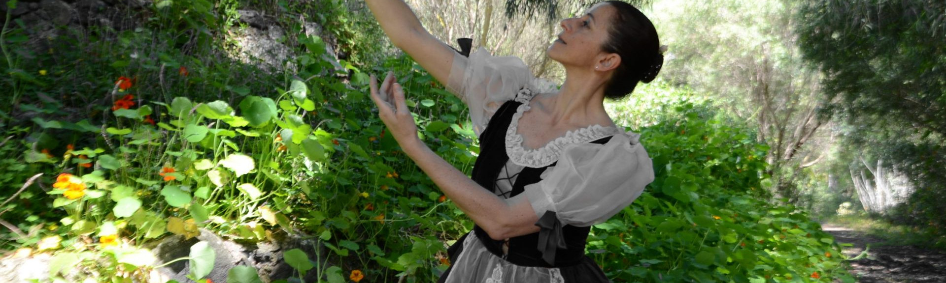 Sandra Santa Cruz baila elevando una flor en la mano en pleno campo rodeada de flores para explicar que los valores son una parte importante de la filosofía 