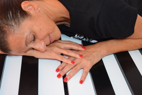 Sandra Santa Cruz_directora del Centro de Danza de su mismo nombre posa sobre las enormes teclas de un piano de grandes dimensiones
